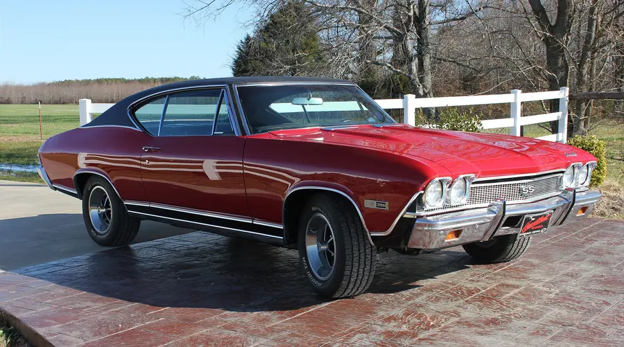 A red restored muscle coupe, wide three-quarter view.
