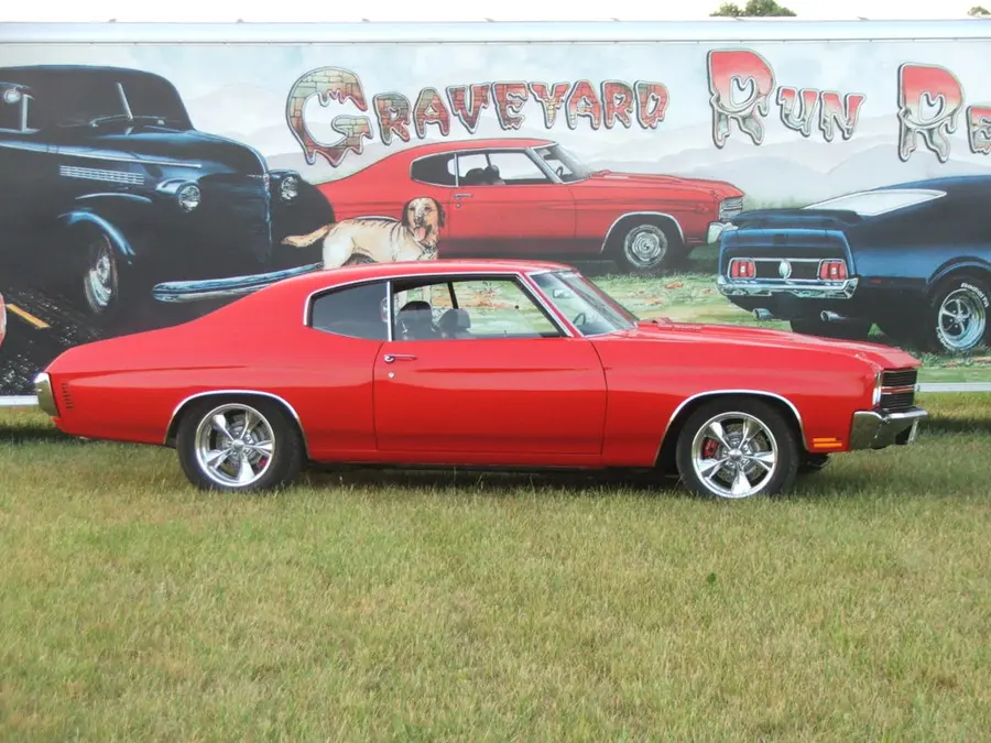 A red restored Chevelle SS in front of the Graveyard Run mural.
