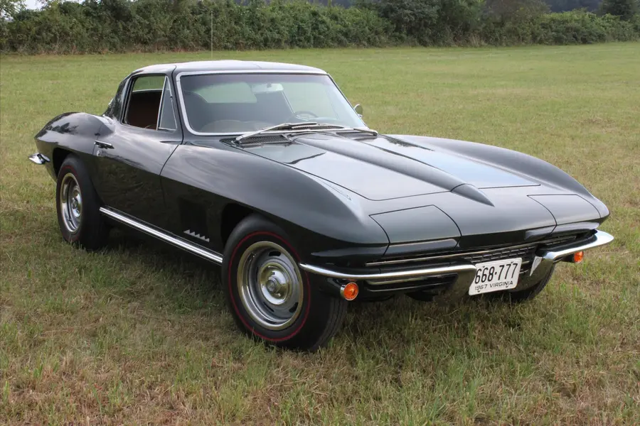 A black restored muscle coupe, aggressive front three-quarter.