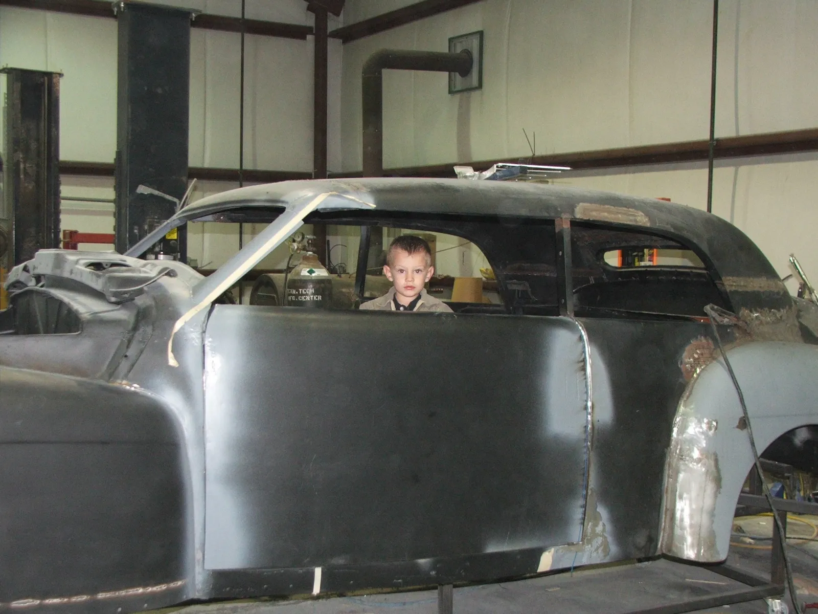 A stripped classic body on the rotisserie during a frame-off restoration