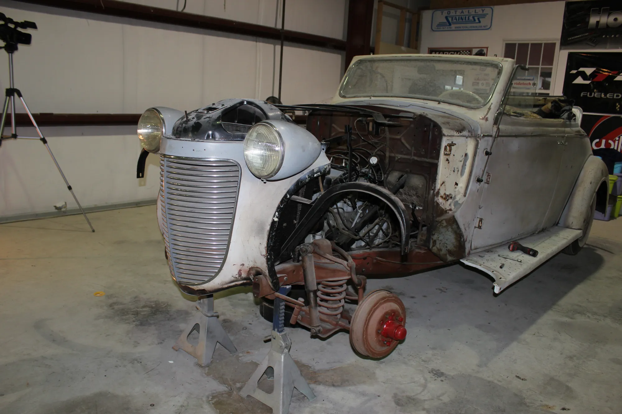 The roadster under tear-down in the shop — front end opened up.